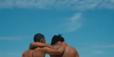 Dos amigos abrazados frente al cielo